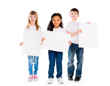 three funny children holding paper blanks in hands