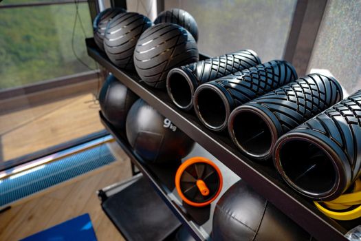 Balls and foam roller sport equipment in a gym on shelf