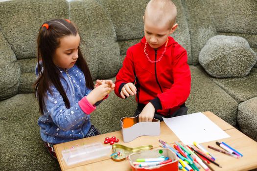 Little toddler girl and boy concentrate work together. boy and girl learn and play together at the table. Children enjoy hand writing. Friendship