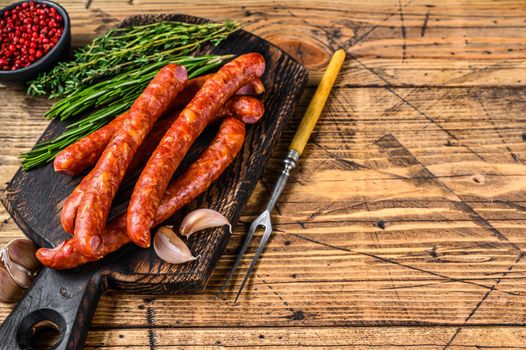 Pork Smoked sausages with addition of fresh aromatic herbs and spices. wooden background. Top view. Copy space