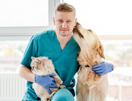 Golden retriever dog licking man veterinarian