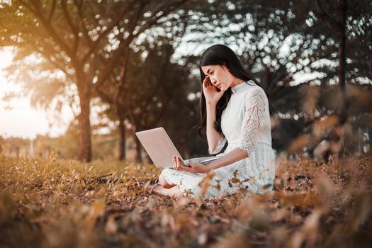 beautiful woman using laptop in the park