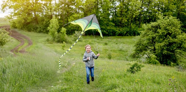 Happy little girl flying bright kite