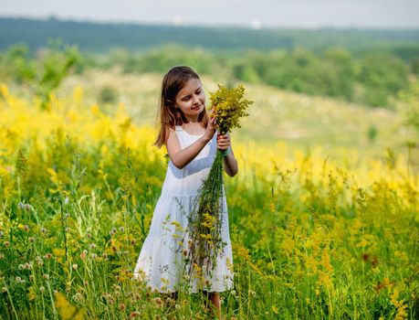 Cute little girl holding wildflower bouquet