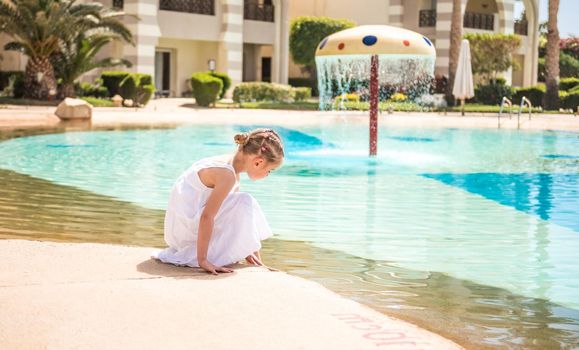 Cute kid walking by the pool