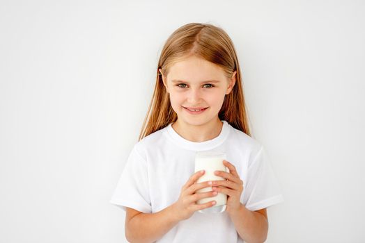 Beatiful schoolgirl kid drinking warm milk