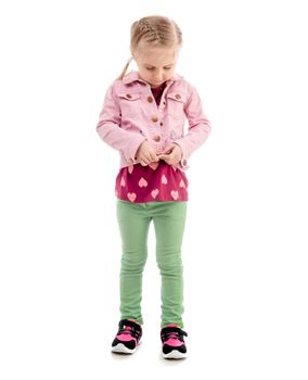 Child trying to zip her pink coat, isolated
