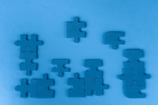 Puzzle pieces on classic blue background, top view