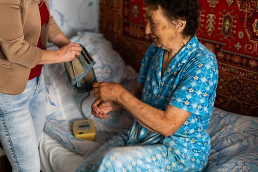 Female doctor measuring blood pressure of senior woman