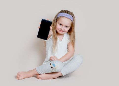 Little girl showing blank screen of mobile phone