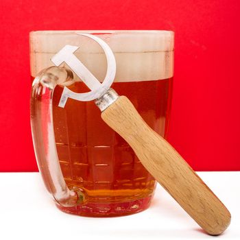 Retro opener from the Soviet era in the shape of a sickle and hammer next to a beer