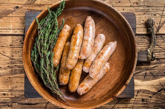 Fried Chorizo and Bratwurst sausages in a wooden plate. wooden background. Top View