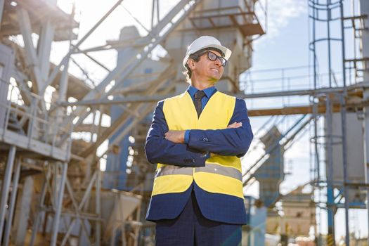 Joyful male worker standing outdoors at factory