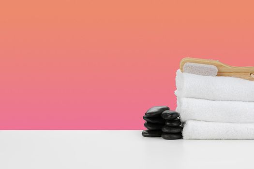 Spa still life with stacked towels and spa stone, front view