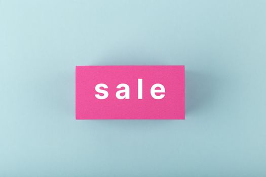 Sale minimal concept. Sale single word on pink rectangle against bright cold blue background