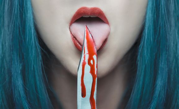 Horror woman licking a knife