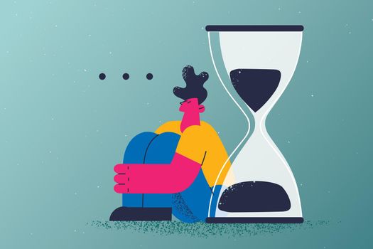 Long wait, delay, appointment concept. Young tired man cartoon character sitting on floor waiting feeling delay exhausted with huge hourglass behind vector illustration