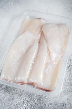 Raw squid or Calamari in a vacuum package from the supermarket. White background. Top view