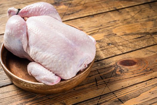 Raw chicken, poultry meat in wooden plate. Wooden background. Top view. Copy space