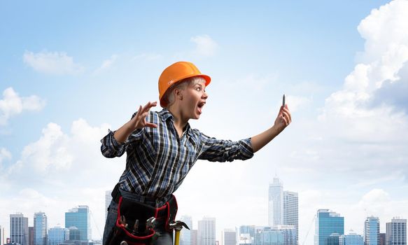 Expressive blonde woman in workwear and hardhat