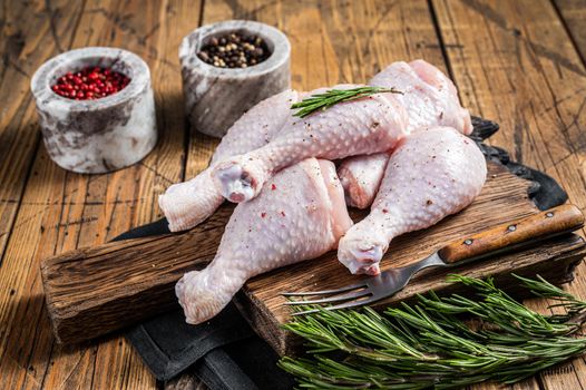 Fresh Chicken drumsticks legs with skin, raw poultry meat. Wooden background. Top view