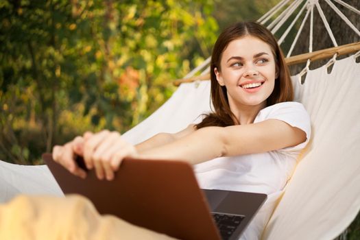 woman with laptop lies in hammock freelance travel