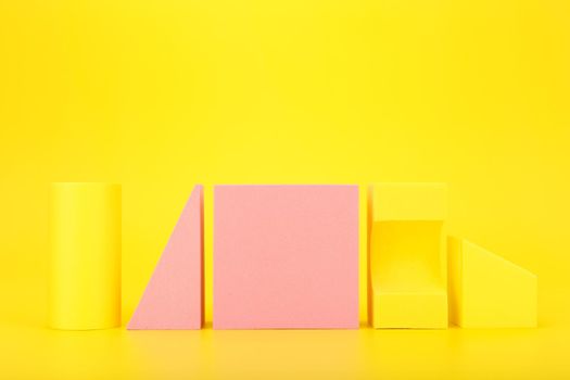 Abstract futuristic background in yellow and pink colors with copy space. Different geometric figures in a row
