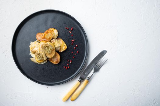 Baked potato and artichoke with fennel al forno, on white textured background, top view with space for text