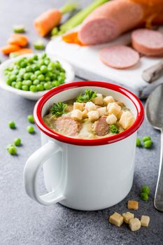 Homemade pea soup with sausage and croutons
