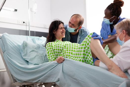 Pregnant woman in painful labor giving birth to child