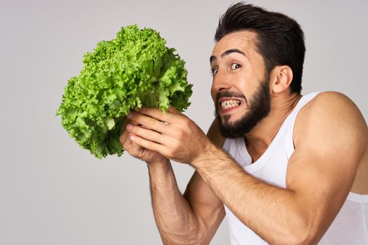 Cheerful man lettuce leaves healthy food posing