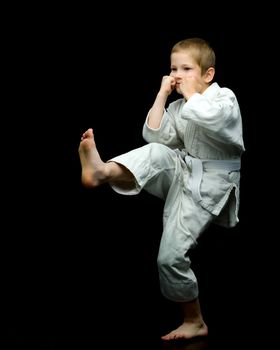 A little boy in a white kimono fulfills blows