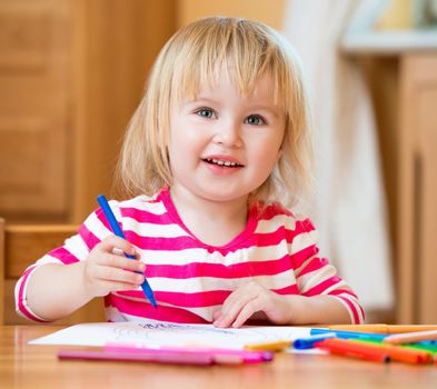 Cute happy little girl draws felt-tip pens