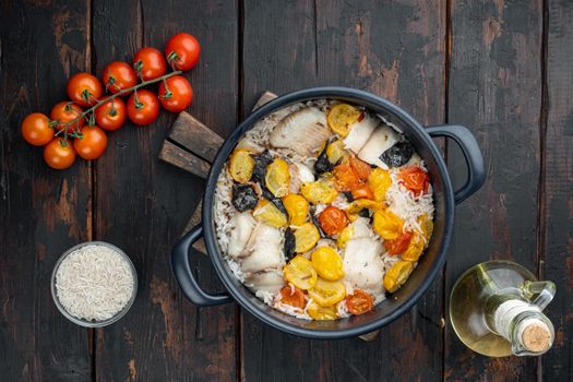 One pan fabulous fish with basmati rice and cherry tomatoes, on old wooden table, top view