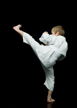A little boy in a white kimono fulfills blows