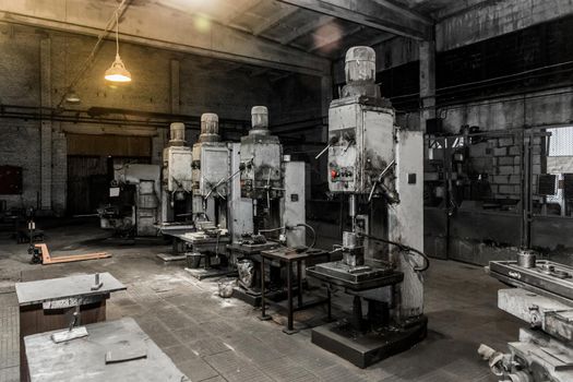Old vertical milling machines equipment with flanged electric motors for metal processing in the workshop of the industrial plant