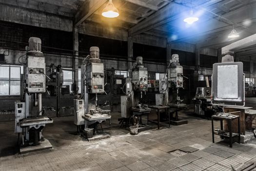 Old vertical milling machines equipment with flanged electric motors for metal processing in the workshop of the industrial plant