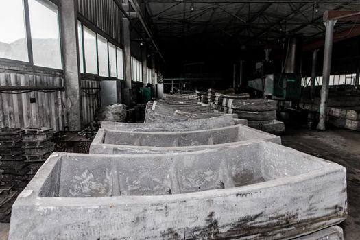 Cast iron tubing reinforced concrete cast products for lining distillation tunnels and underground structures are stored in the warehouse of the industrial plant