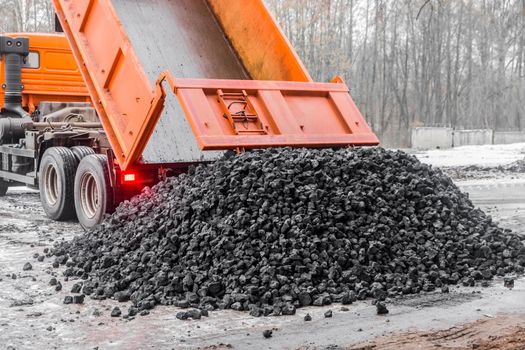 Dump truck in the industrial zone unloads coking coal from the body