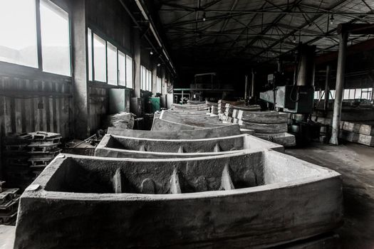 Cast iron tubing reinforced concrete cast products for lining distillation tunnels and underground structures are stored in the warehouse of the industrial plant