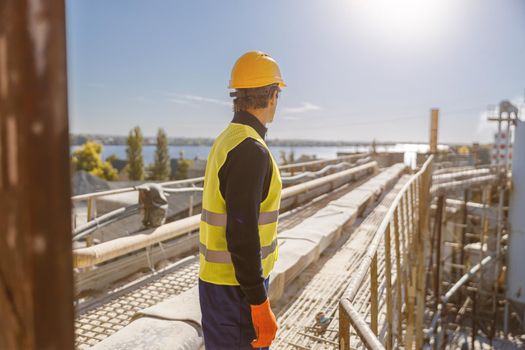 Male worker standing outdoors at industrial site