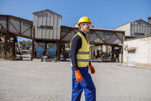 Male engineer standing outdoors at industrial site