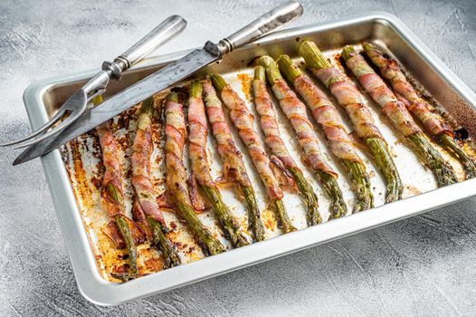 Asparagus Wrapped in Bacon on a Barbecue tray. White background. Top view