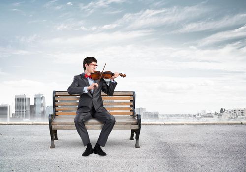 Young businessman plays the violin