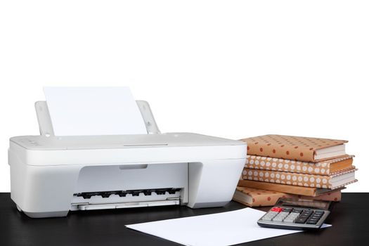 Printer and stack of books on black table against white background