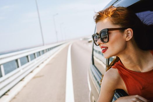 woman looking out of car window wearing sunglasses travel lifestyle. High quality photo