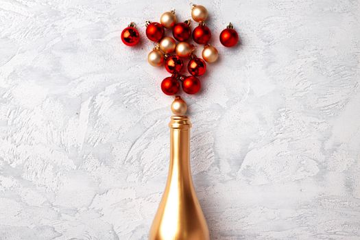 Flat lay composition with gold champagne bottle and Christmas balls