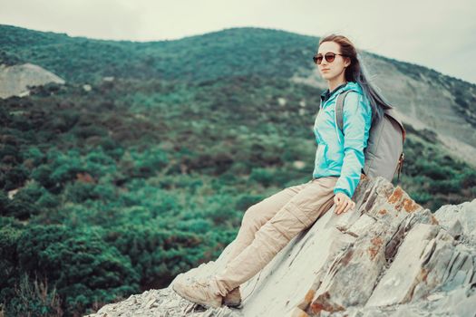 Traveler girl resting on rocks