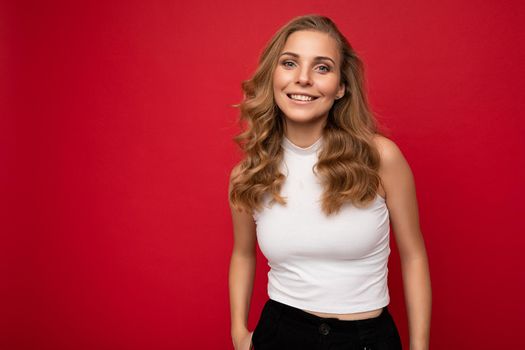 Photo portrait of adult charming fascinating attractive happy smiling delightful blonde woman with sincere emotions wearing stylish clothes isolated over red background with copy space