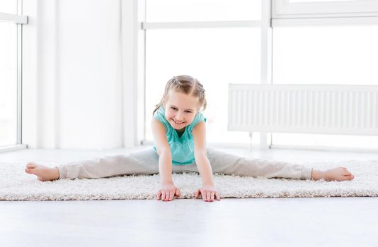 Smiling girl stretching at home